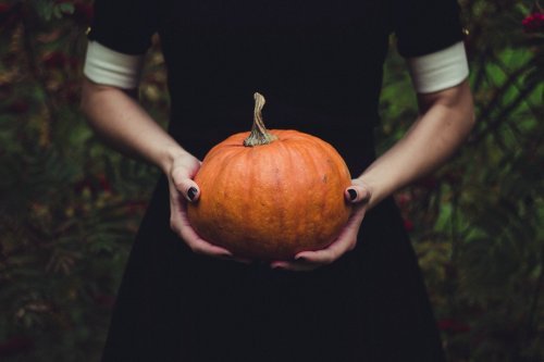 femme tenant une citrouille d’Halloween